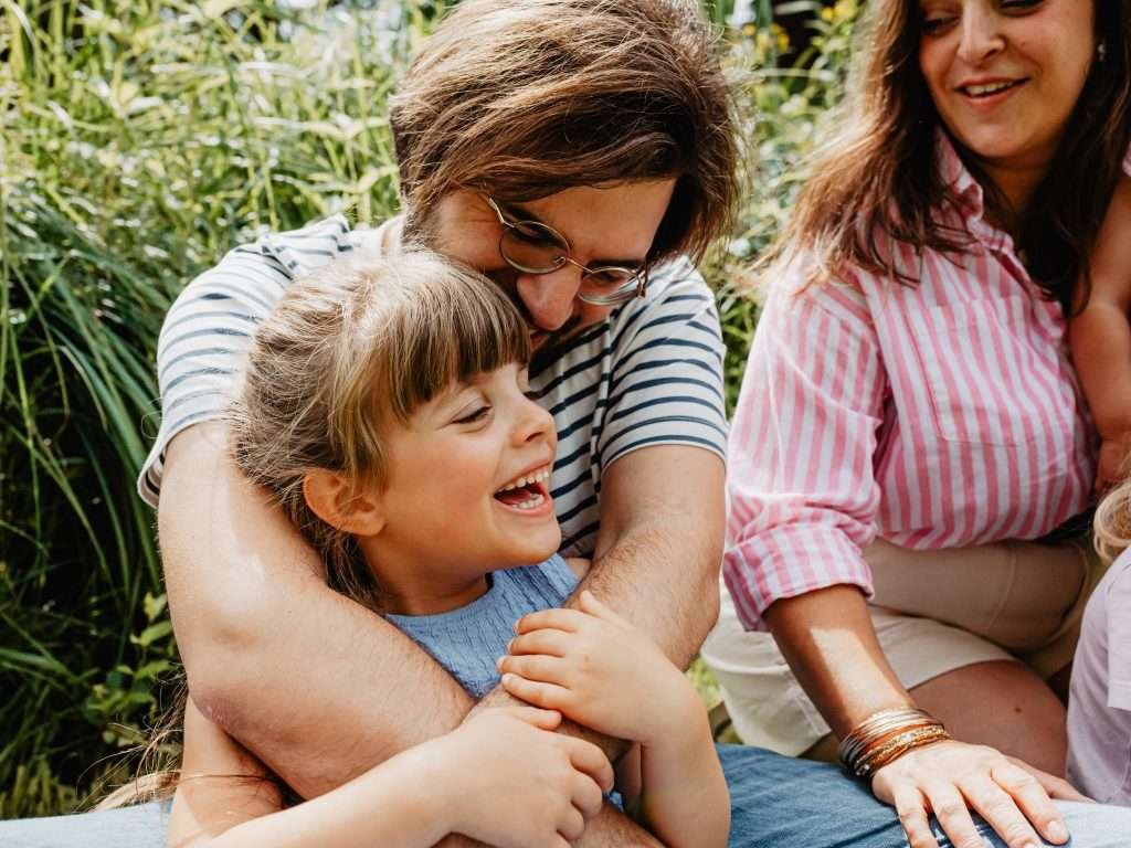 Famille riant ensemble dans un parc à Lille pendant une séance photo lifestyle